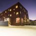 Svalbard Hotell | The Vault in Longyearbyen, exterior at night with snow-covered ground