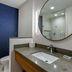 Fairfield by Marriott Inn & Suites Sandusky bathroom with round mirror, vanity sink and blue accent wall