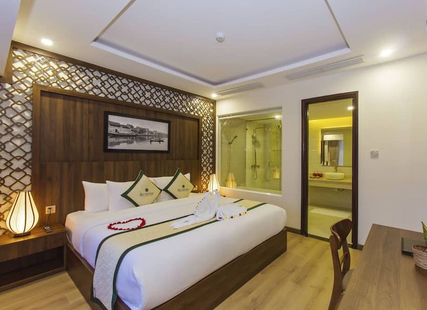 Ally Beach Boutique Hotel Hoian in Hoi An: modern guest room with king bed, desk and bathroom doorway