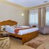 Kilimo Grand Resort in Nairobi: guest room with wooden bed, armchairs, side table and window curtains