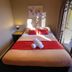 Haka Lodge Christchurch room with double bed, red bedding, and sliding glass door to patio