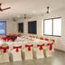 Le Pearl Goa Resort & Spa in Vagator meeting room set for a conference with U-shaped tables and red chair bows