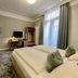 Hotel West an der Bockenheimer Warte guest room with bed, desk, TV and tall windows in Frankfurt am Main