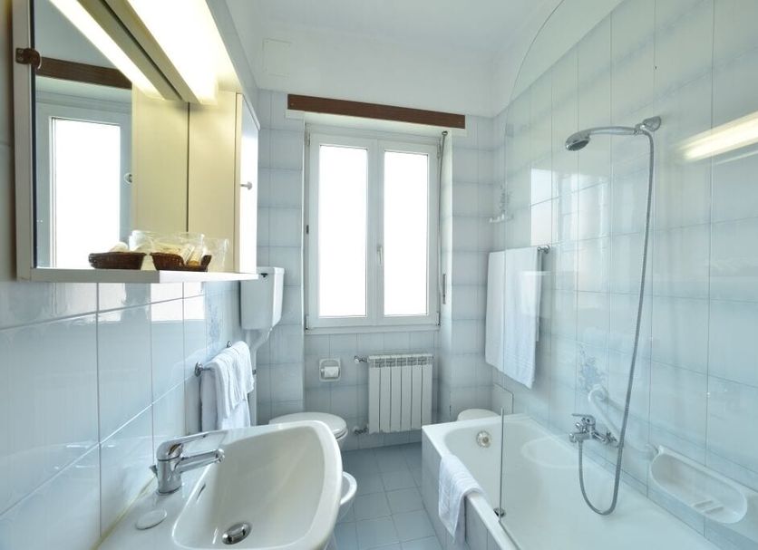 Hotel Bergamo Mare Mhotelsgroup bathroom in San Bartolomeo al Mare with sink, bathtub, shower and window