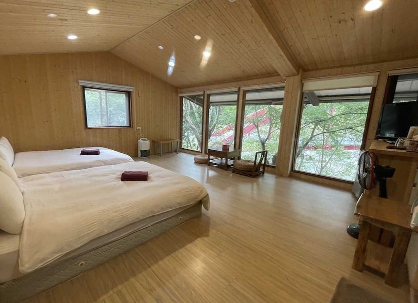 Mhuwe hotspring guest room in Ren-ai Township with two beds and large windows overlooking trees