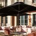 Tribe Le Touquet courtyard seating with large black umbrellas and cushioned lounge chairs in Le Touquet