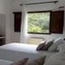 Agroturismo Ca Sa Vilda Marge room with twin beds and an open window to green countryside in Sant Joan de Labritja