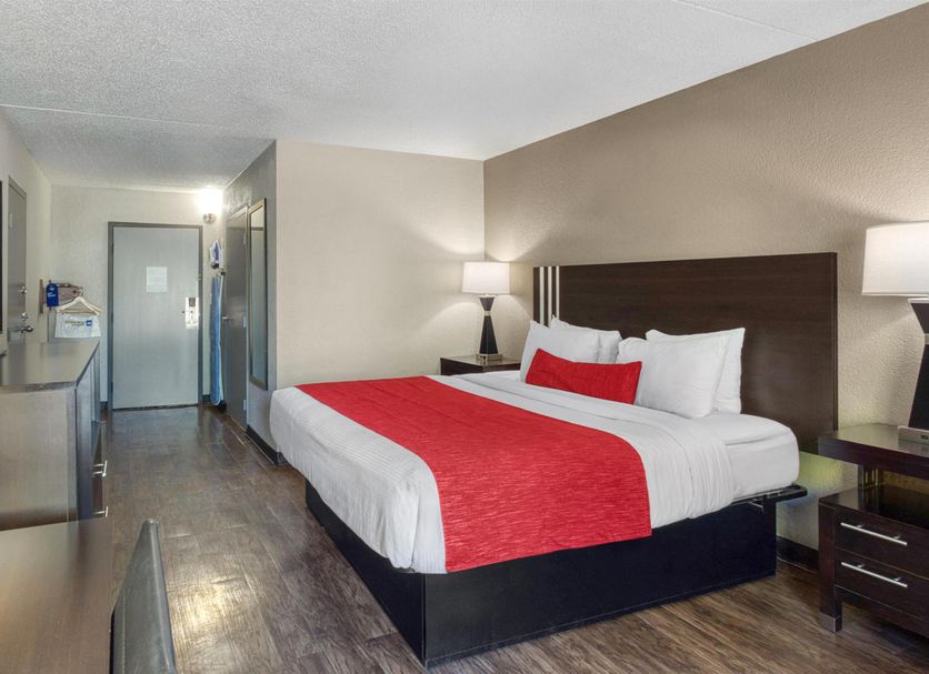 SureStay by Best Western Greenville guest room with king bed, red runner, TV, and mini-fridge