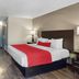 SureStay by Best Western Greenville guest room with king bed, red runner, TV, and mini-fridge