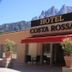 Hotel Costa Rossa in Porto with mountain backdrop, terrace seating, and potted flowers