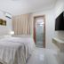 Golden Dolphin Supreme Caldas Novas guest room with twin beds, wall-mounted TV, and bathroom doorway