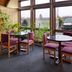 Red Carpet Inn North East lounge with round tables, purple chairs, and large windows overlooking a parking lot.
