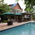 Elite Hotel Port Au Prince poolside terrace with loungers, umbrellas and tropical greenery