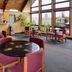 Red Carpet Inn North East lounge with tables, chairs, and large windows overlooking the grounds