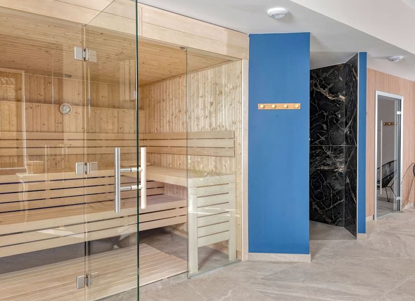 Mas de la Senancole in Gordes: glass sauna beside a blue wall and spa shower area