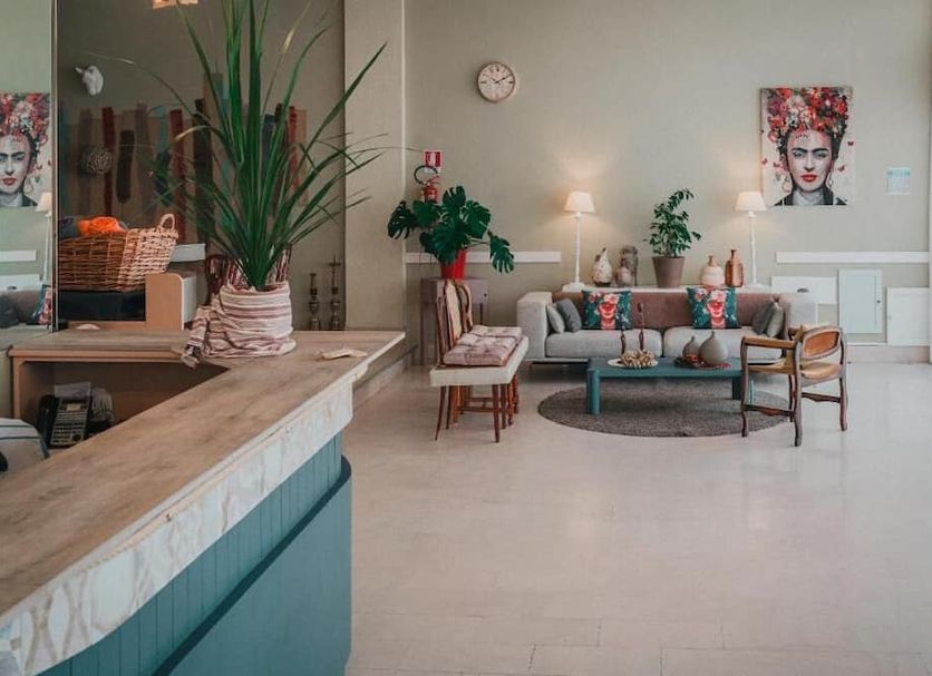 Amadei Hotel Promenade lobby in Pesaro with seating area, reception desk and tall potted plant