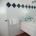 Karibu Aruba in Noord bathroom with double sink vanity, mirror, and black diamond wall tiles