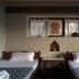 Tushita Nepal Yoga Retreat Center in Pokhara, twin beds in a rustic guest room with stone wall and window