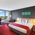 Holiday Inn Melbourne Airport By IHG guest room with king bed, desk, chair, lounge chair and airport views in Melbourne
