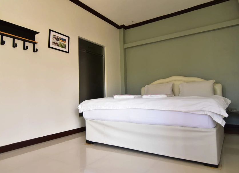 Bangrak Resort in Nakhon Sawan bedroom with a bed, wall shelf, and framed picture