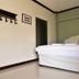 Bangrak Resort in Nakhon Sawan bedroom with a bed, wall shelf, and framed picture