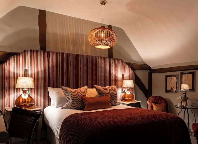 Bel and The Dragon-Cookham in Maidenhead bedroom with king bed, striped accent wall, and bedside lamps