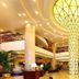 Grand Metropark Hotel Shangqiu lobby with soaring columns, warm lighting, and a grand central chandelier