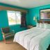 Best Motel Bowling Green guest room with queen bed, turquoise walls, window, and bedside lamps