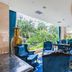 Century Palace Hotel Huiyang in Huizhou lounge with blue chairs and large garden-view windows
