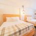 Innsbruck Inn at Stowe room with two wooden beds and plaid bedding in Stowe