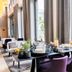 Best Western Plus Welcome Hotel Frankfurt lounge with dining table by large windows and city greenery view