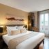 Best Western Plus Hotel Belfort Centre Gare guest room with bed, desk, balcony door and TV in Belfort