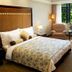 Wuzhou Guest House Shenzhen guest room with king bed, armchair and large window overlooking green gardens