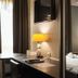 Hotel Orion Ghent guest room with bed, desk, wall-mounted TV, and window light