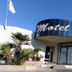 Hotel Amerique in Palavas-les-Flots exterior with curved blue motel-style entrance and palm trees