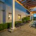 Home2 Suites by Hilton Saratoga Malta patio with covered seating and outdoor dining area at dusk
