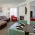 Residence Inn by Marriott Portsmouth living area with sectional sofa, chair, fireplace and dining table