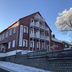 Apartments Fichtelberger Blick in Oberwiesenthal, red hotel building with balconies and snowy tree