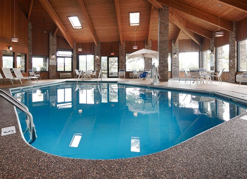Baymont by Wyndham Delaware indoor pool with lounge chairs and vaulted wood ceiling