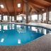 Baymont by Wyndham Delaware indoor pool with lounge chairs and vaulted wood ceiling