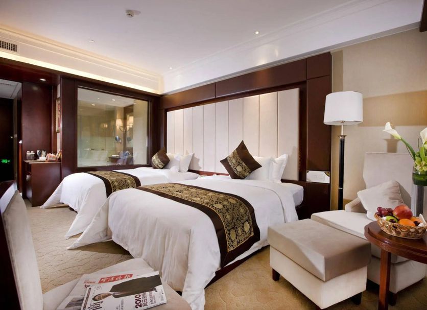 Shuguang Liting Hotel Ningbo guest room with two neatly made beds and a seating area