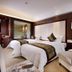 Shuguang Liting Hotel Ningbo guest room with two neatly made beds and a seating area