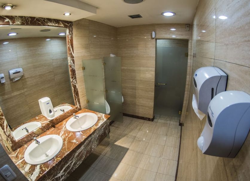 Hotel Emperador Ambato restroom with double sinks, large mirror and wall-mounted hand dryers