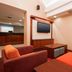 Residence Inn by Marriott Davenport lounge with orange and burgundy seating, tables, and TV