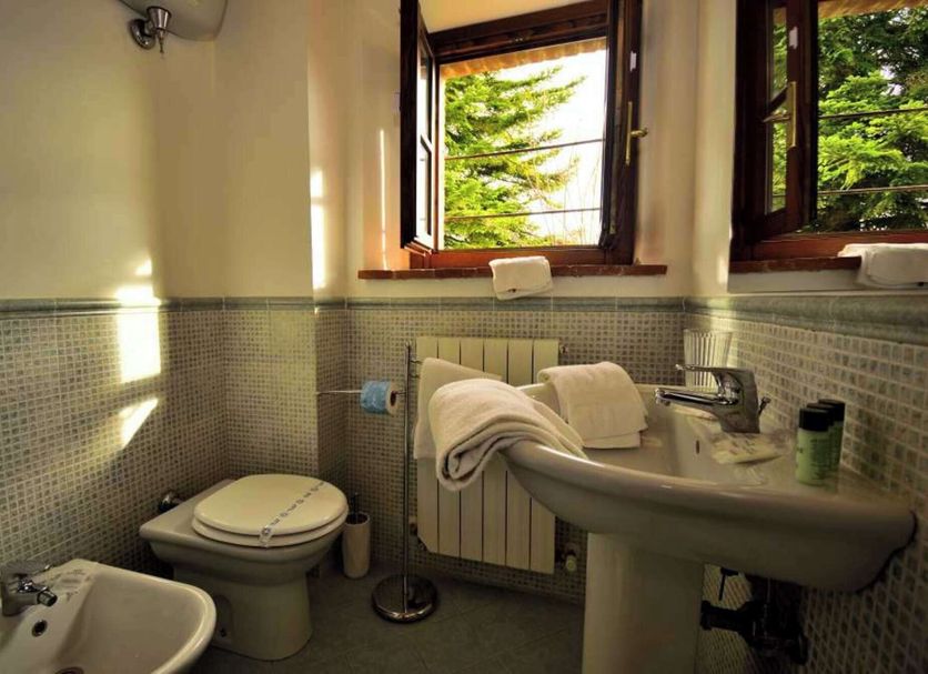 Le Rocche di Valiano bathroom with bidet, toilet, sink and open window in Vagliagli