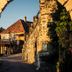Hotel Jufa Deutschlandsberg stone archway frames a sunlit courtyard with a historic building in Deutschlandsberg