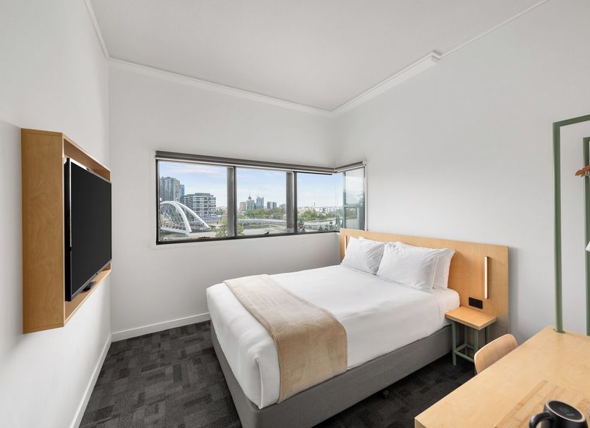 Yha Brisbane City Brisbane room with bed, city-view corner window and wall-mounted TV