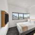 Yha Brisbane City Brisbane room with bed, city-view corner window and wall-mounted TV