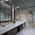 Hyatt Centric The Woodlands bathroom with double vanity, glass shower, and freestanding tub