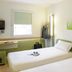 Ibis Budget Dresden Kesselsdorf room with two single beds, desk, wall TV, and window in Kesselsdorf.
